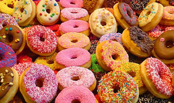 A bunch of different colored donuts are on the table